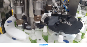 Rotary filler machine filling and capping bottles with liquid on an automated packaging line.